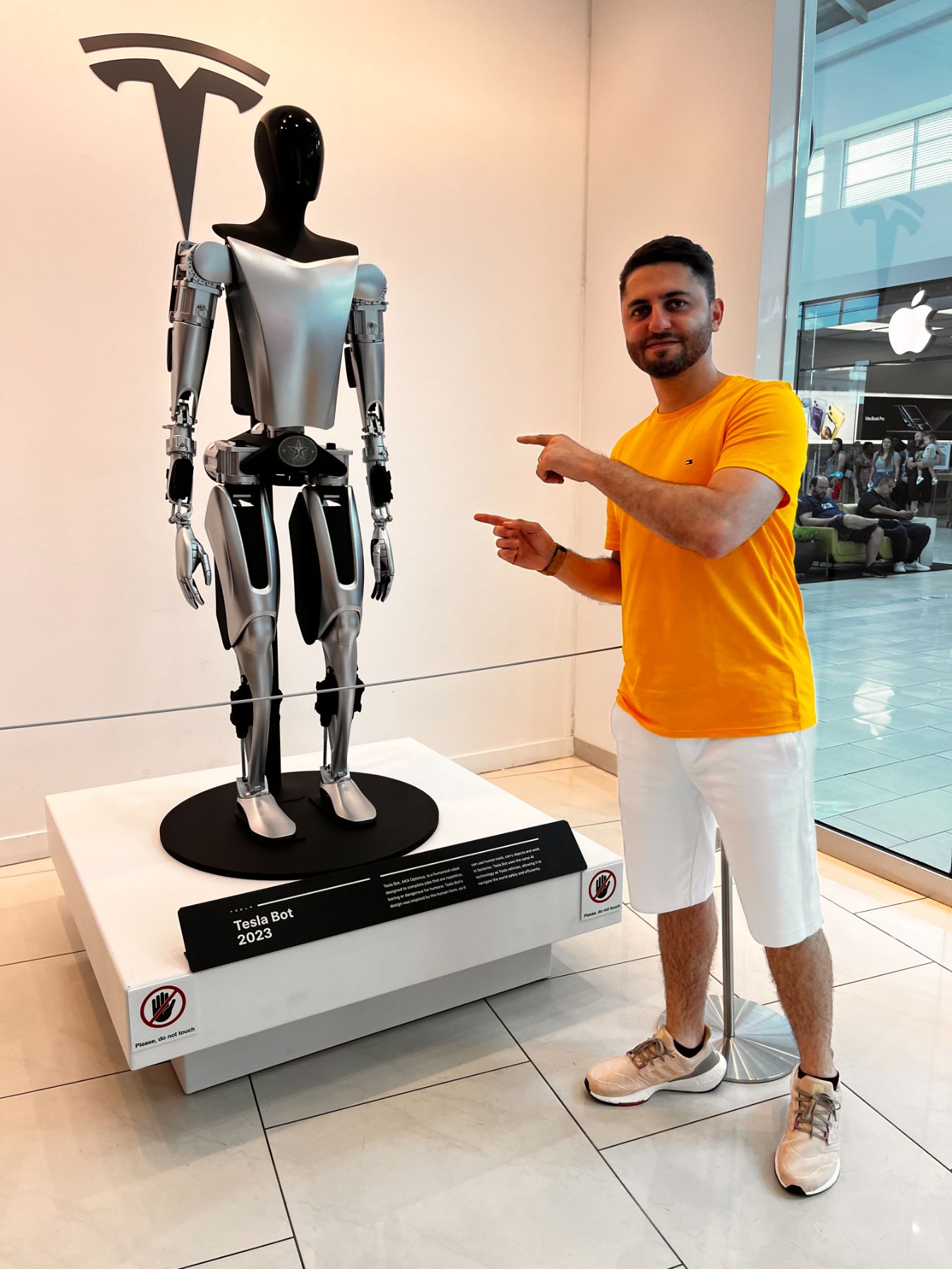 Guilherme Lima apontando para um robô humanoide em exposição